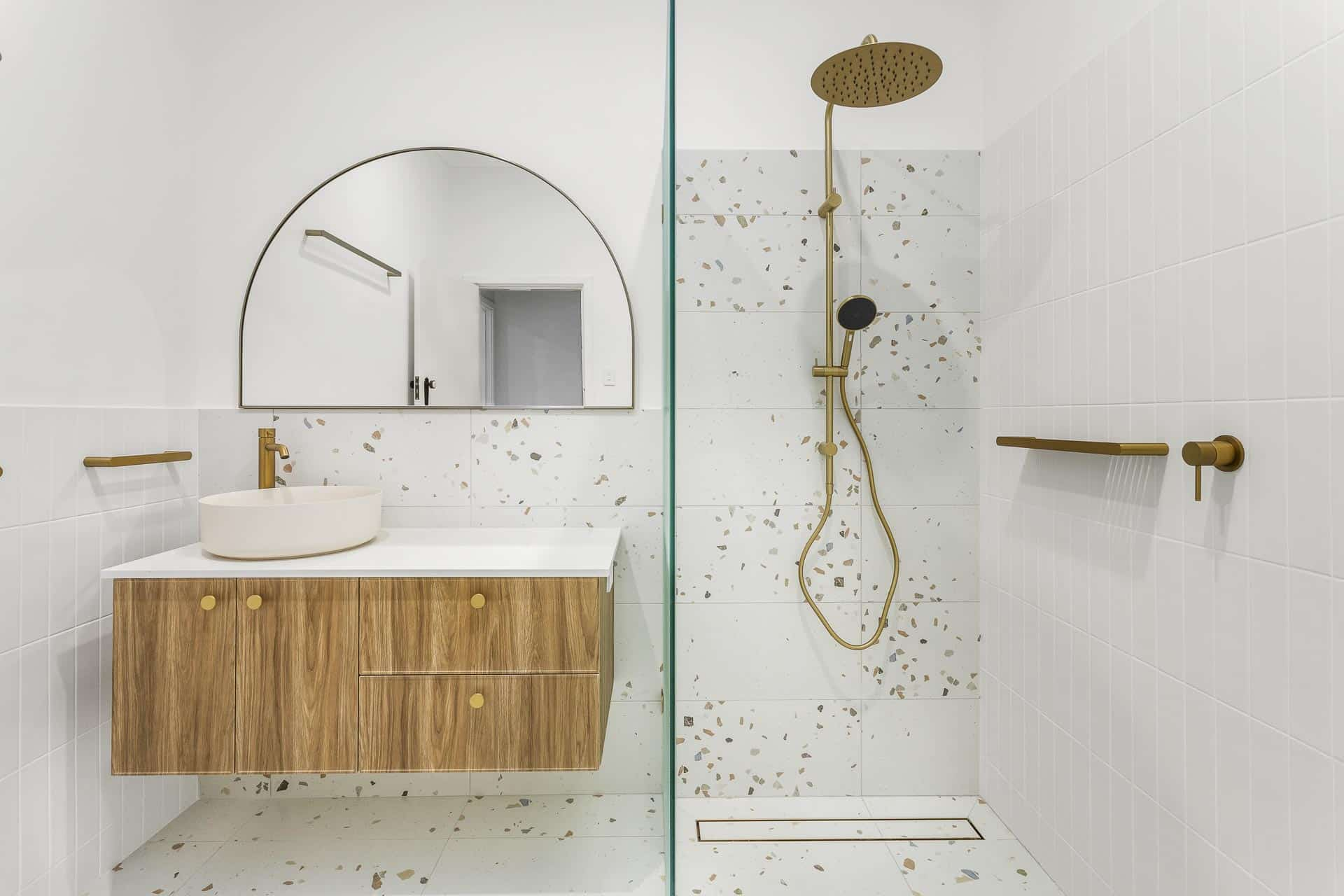 Modern bathroom with gold fixtures and terrazzo tiles