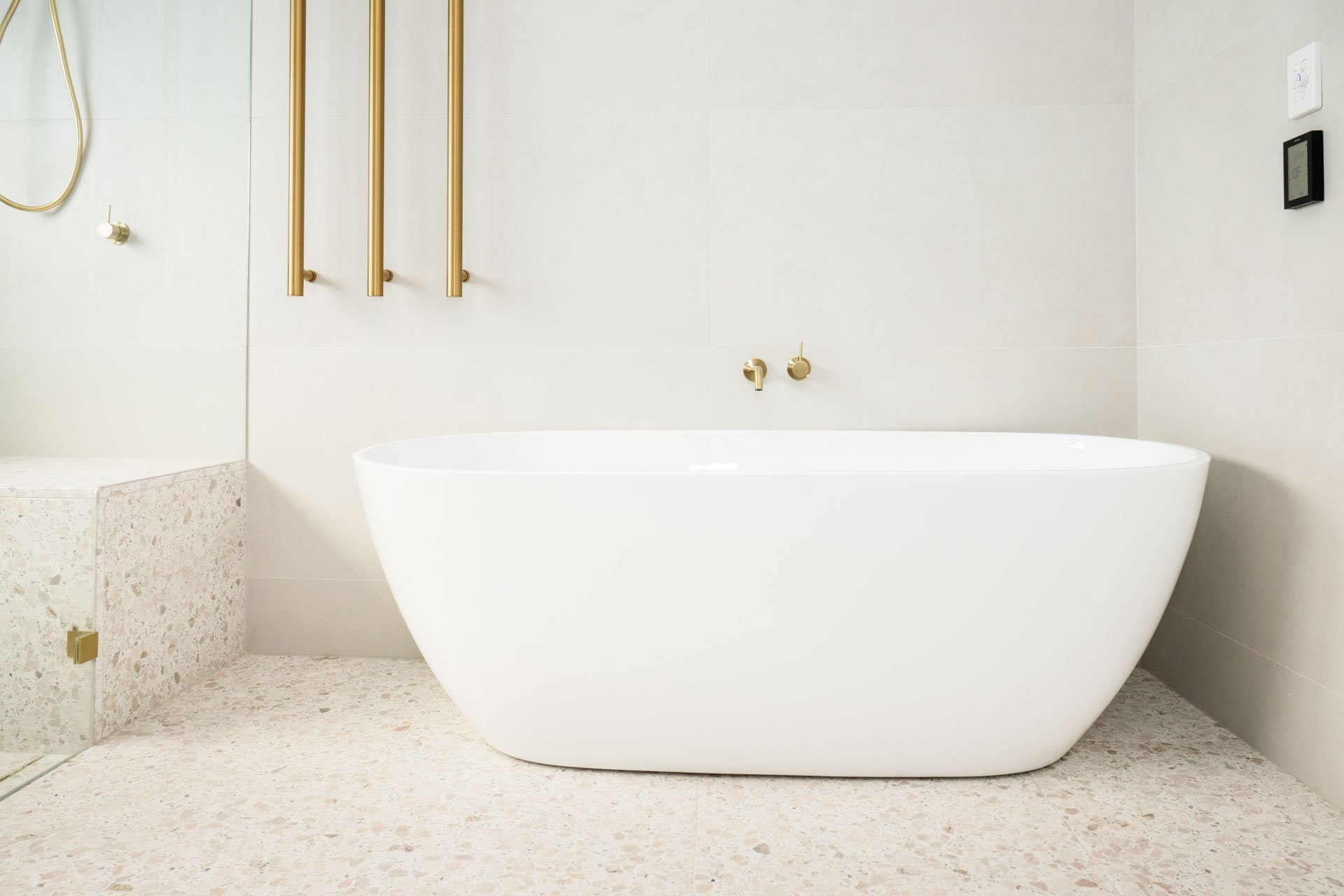 Elegant bathroom with white tub and gold fixtures